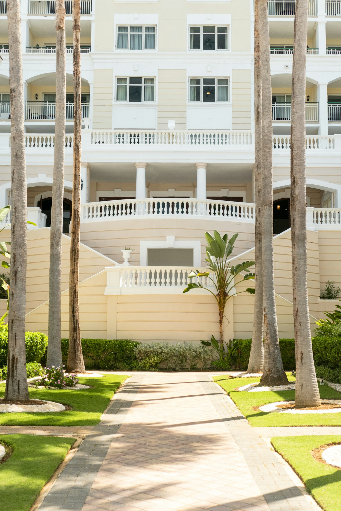 Caribbean residential building with palm-lined walkway